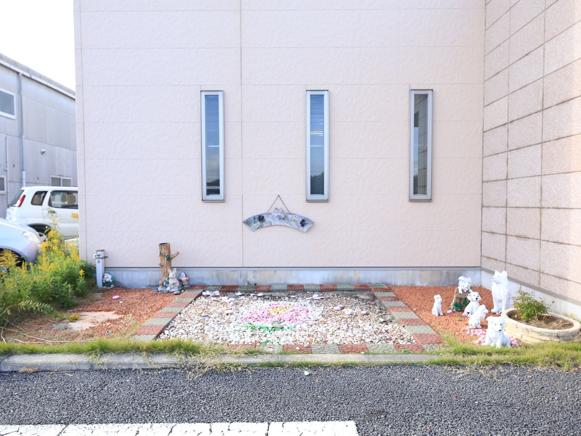 建物の脇に設けられた中庭である。四角の枠の中に小石が入っている。周りにウサギや子犬などの動物のモニュメントが置かれている。