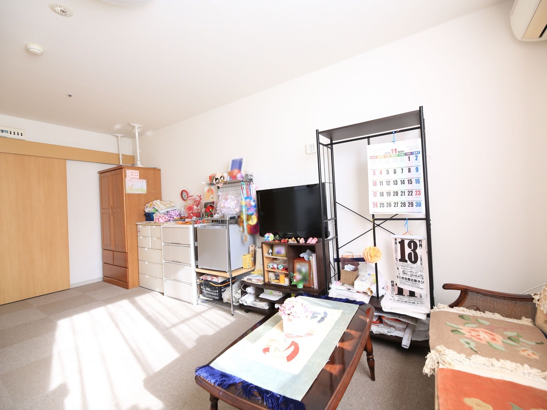 壁際に、収納ダンス、収納ケース、冷蔵庫、テレビなどがきれいに並んでいる。タンスには地震対応策が施されている。