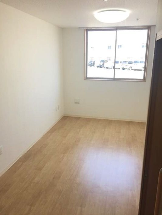 照明がある明るい部屋。窓の外に周辺景色が写っている