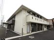 施設は、ベージュ色とダークブラウンの２色が使われた外壁になっている。２階部分にはベランダが設置されている。