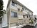 施設は外壁がベージュ色の２階建ての建物である。外階段が設置されており、緊急時の避難経路が確保されている。