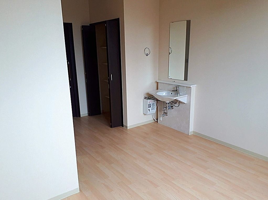 洗面台が写っている部屋の一角。トイレがある様子も分かる