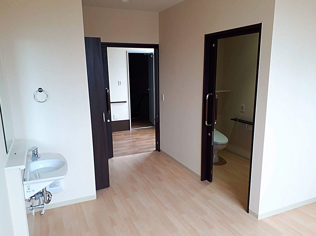 トイレと洗面台が写っている部屋の一角。出口も写っている