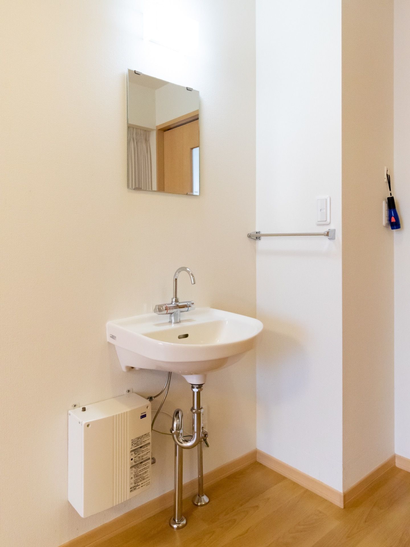 部屋には、シンプルな造りのコンパクトな洗面台がある。壁に鏡が設置してあるため、身支度しやすい。タオル掛けの位置も低く、使いやすい。