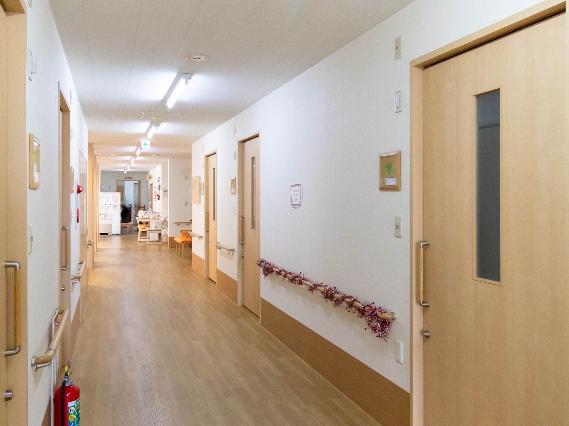 真っ直ぐ続く通路には、一定の感覚を空けて部屋のドアが並んでいる。壁の手すりによって、体を安定させながら移動できる。