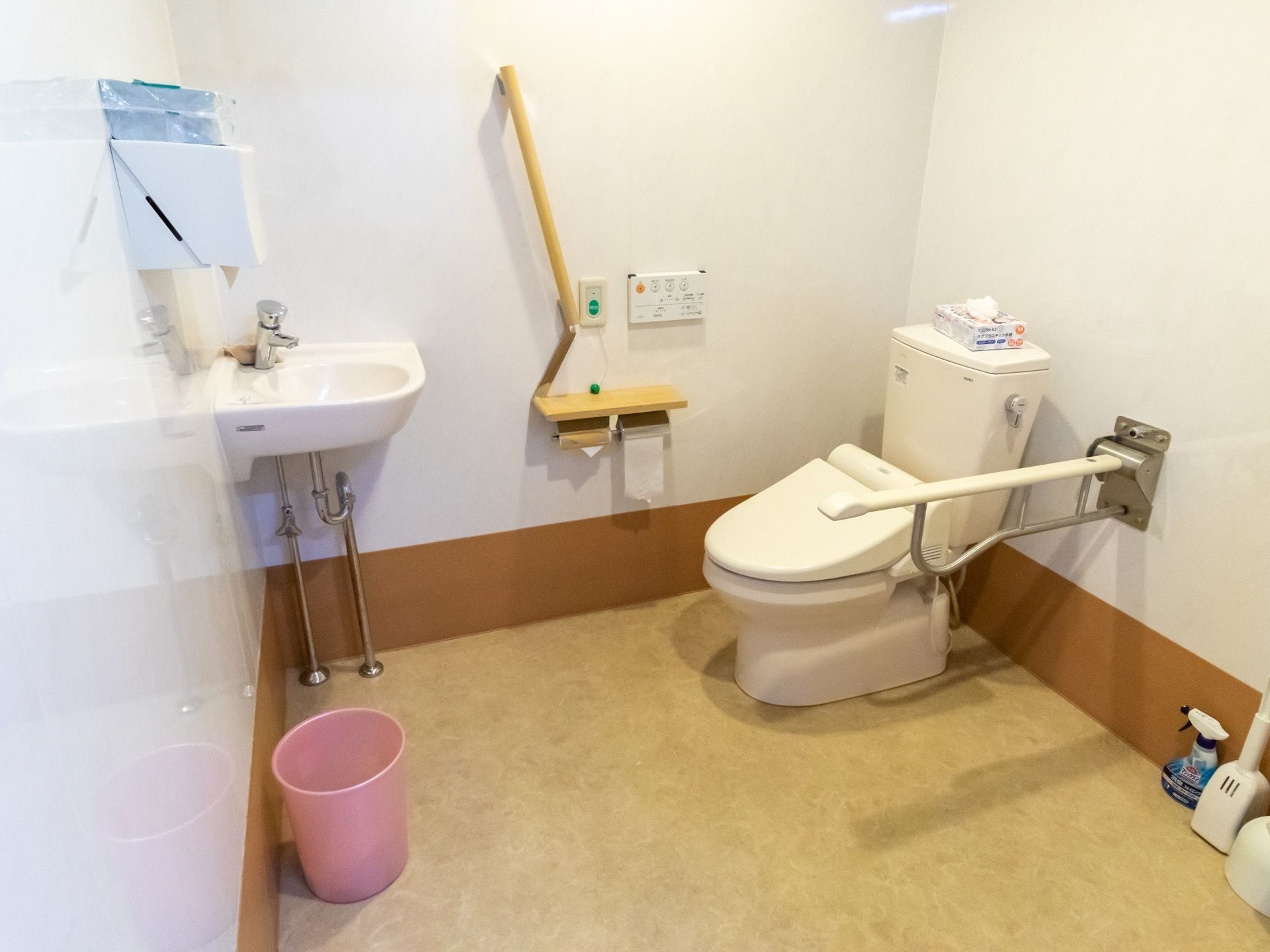 広々とした個室トイレである。便器の真横と壁に手すりがあり、立ち座りの動作や移動がしやすくなっている。