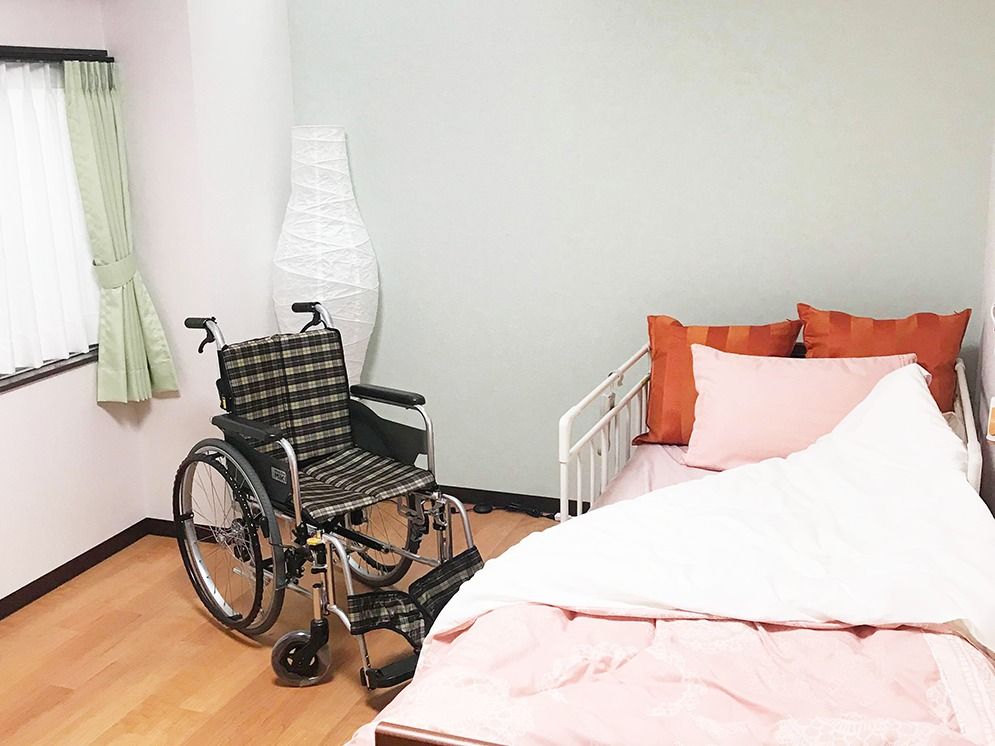 一人用のベッドと車いすが写っている部屋の様子