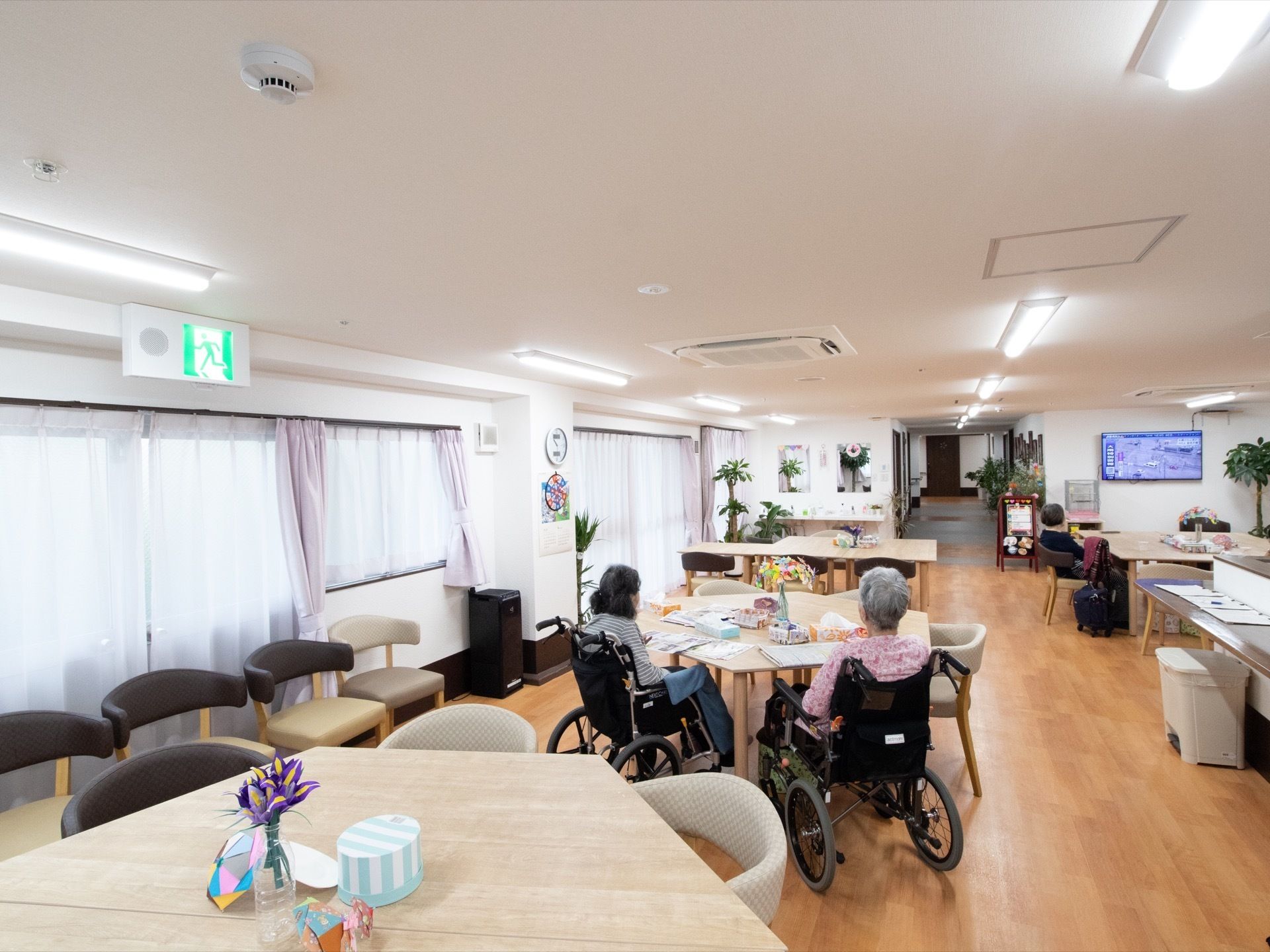 広々としたリビングの横側には、ガラス戸が並んでいる。所々に観葉植物を飾り、緑豊かな空間を設けている。