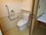 トイレは温水洗浄便座が設置されており、壁には手すりや呼び出しボタンなどが付いている。便器の後ろには小さな棚がある。
