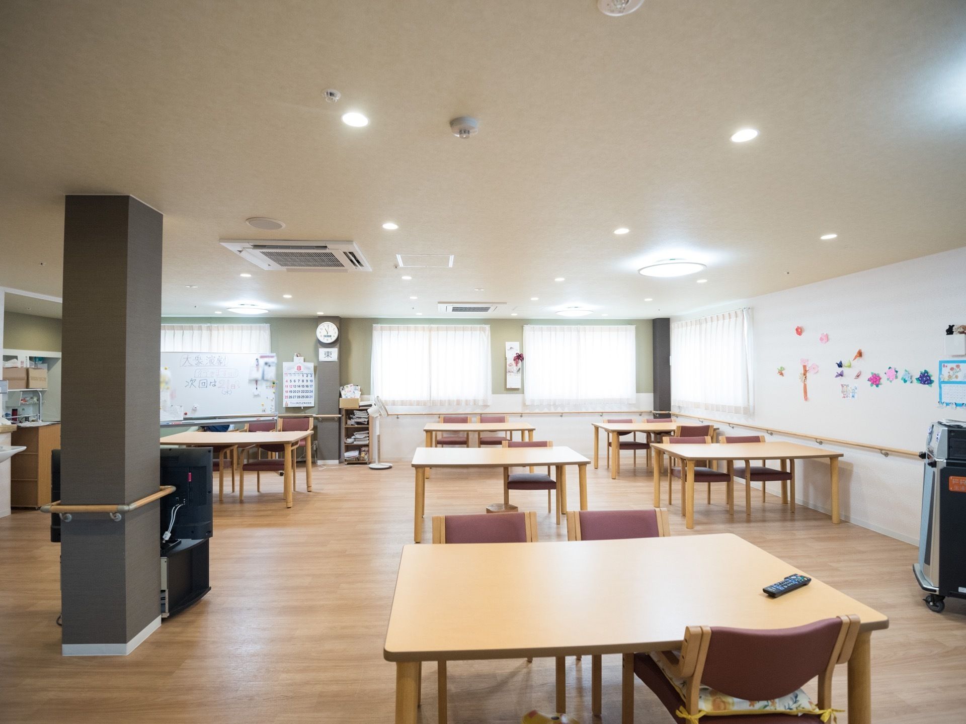 食堂の隅にホワイトボードが置かれている。テーブルなどの家具は、木のぬくもりが感じられるデザインで統一されている。