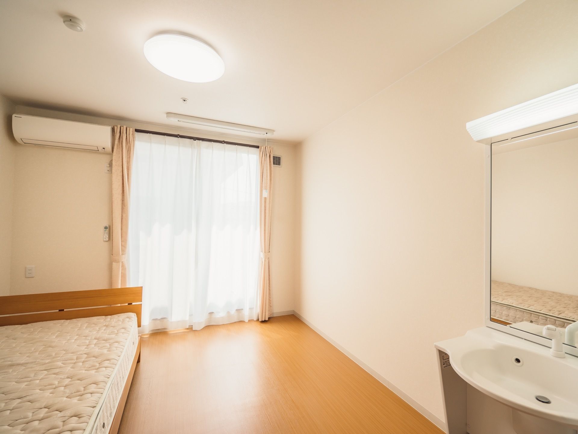 大きな鏡の付いた洗面台が、居室の右側に取り付けられている。鏡の上には細長いライトがあり、周辺を明るく照らしている。