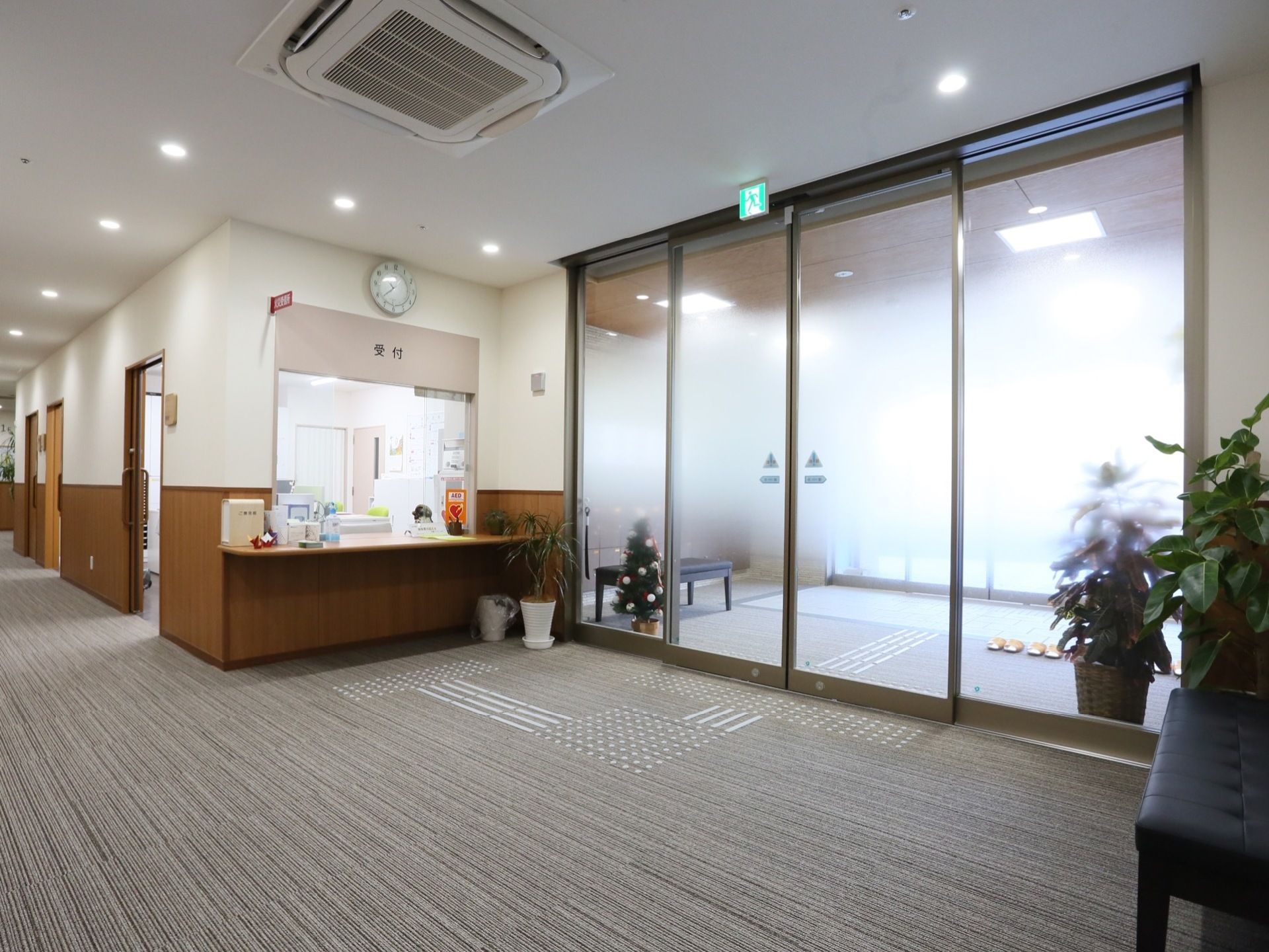 2重玄関で、扉は自動ドアになっている。上部に避難誘導灯が設置されている。玄関を入ってすぐのところに受付がある。