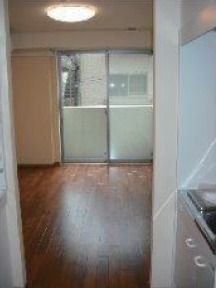 手前にキッチンが写っている部屋の一角。奥にはベランダがある