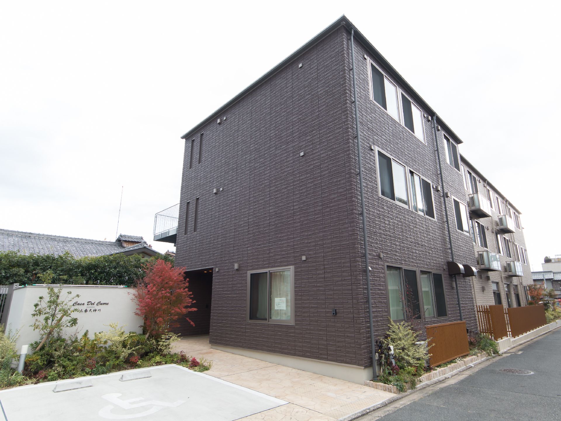 建物のそばに駐車スペースを備えた、落ち着いた雰囲気の施設