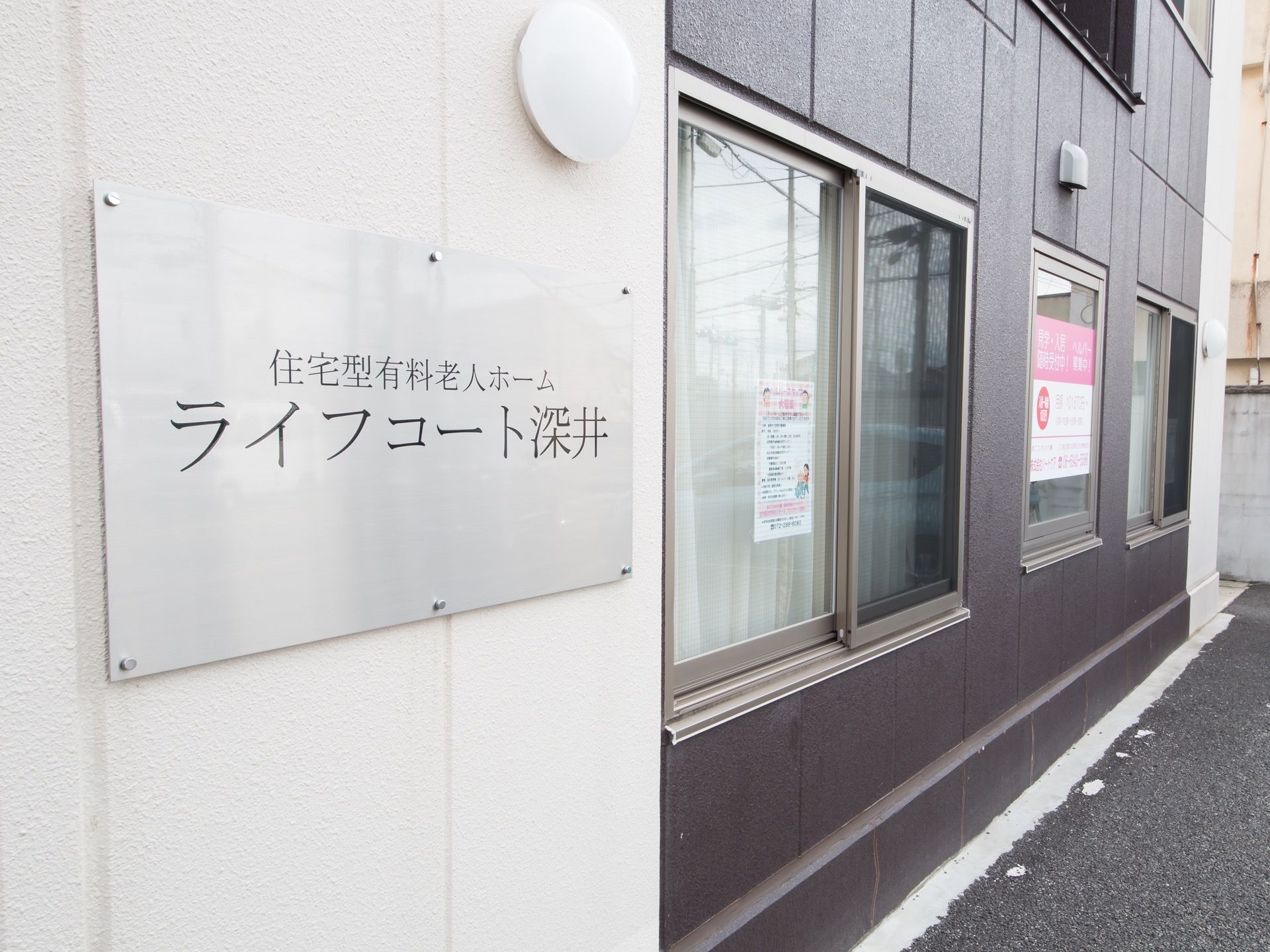 施設は鉄骨造りの４階建てで、焦げ茶色と白のツートンカラーの外観である。施設名は、すっきりとした書体の明朝体で表示されている。