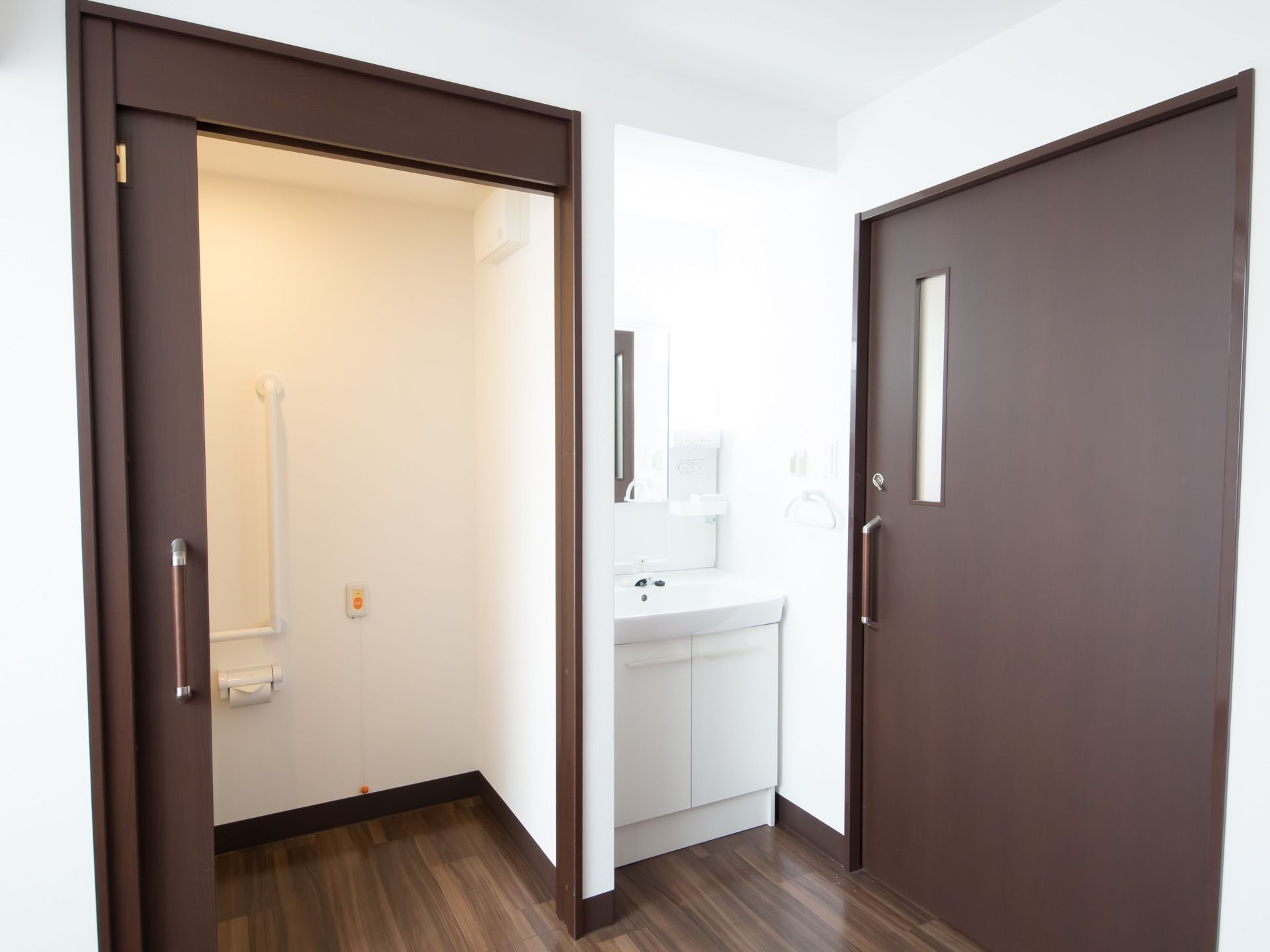 居室の入り口や室内のトイレの扉はスライド式の物が採用されている。居室に入って右手には白い洗面台がある。