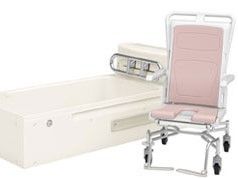 ピンク色の浴室用車いすと白い寝台浴。最新の入浴設備がそろっている。