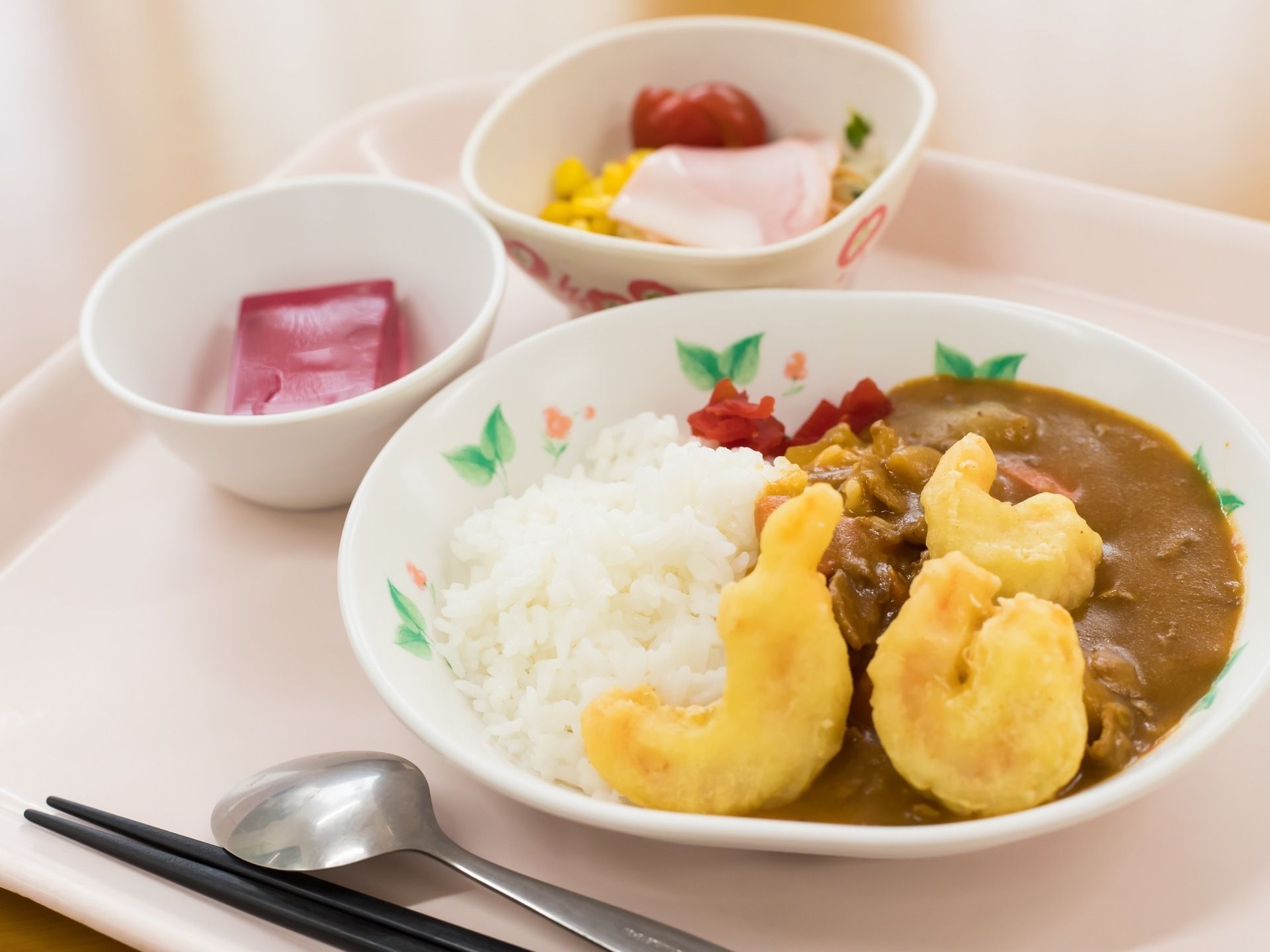 トレイの上に、カレーライス、サラダ、ゼリーの器が置かれている。いずれもスプーンですくって食べることができる、食べやすいメニューである。