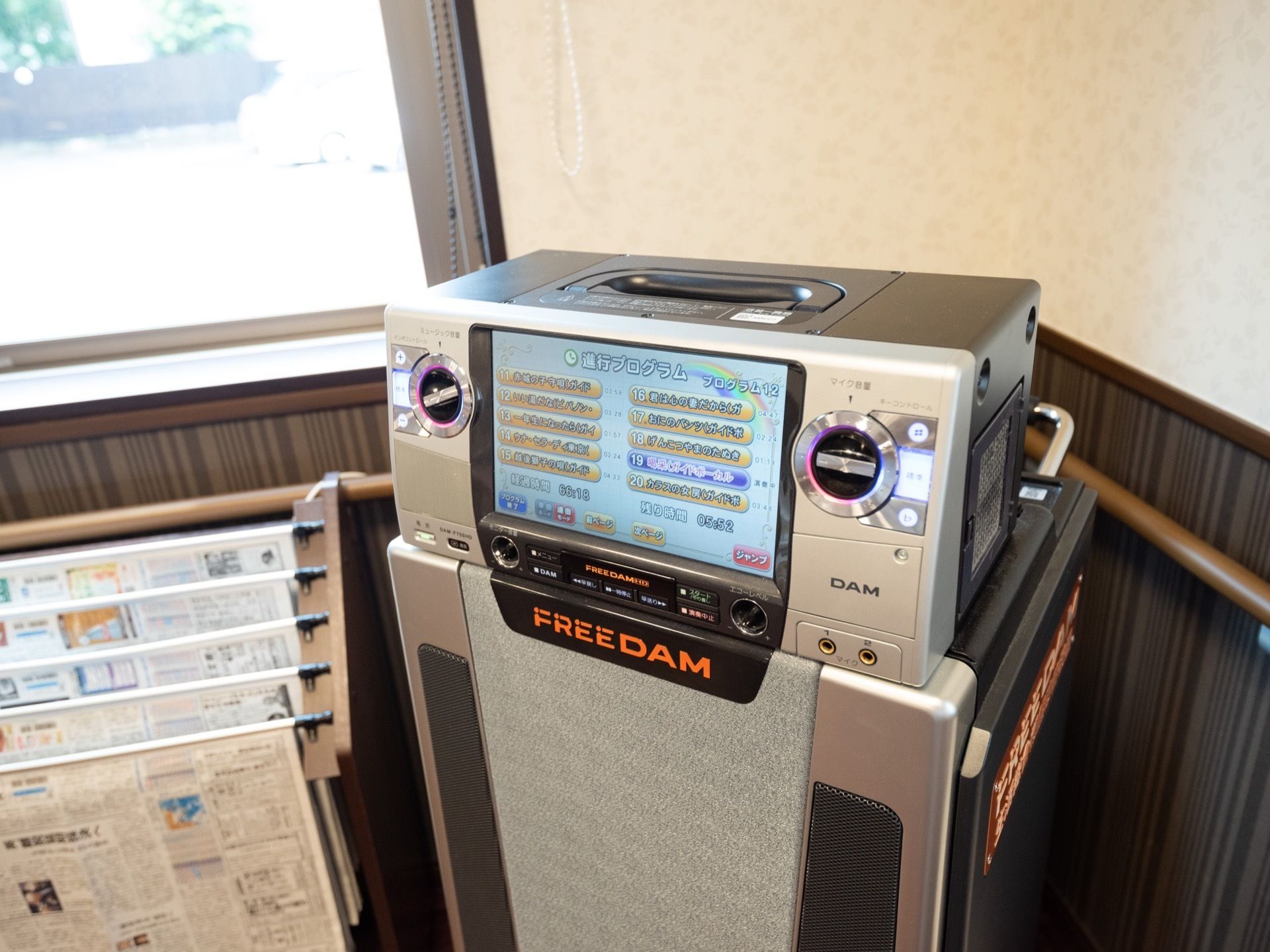 食堂には、カラオケ機器を用意。壁に沿って手すりが取り付けられており、窓際に新聞ラックがある。