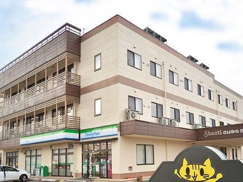 １階にコンビニがある３階建ての建物の様子。やわらかい色合い