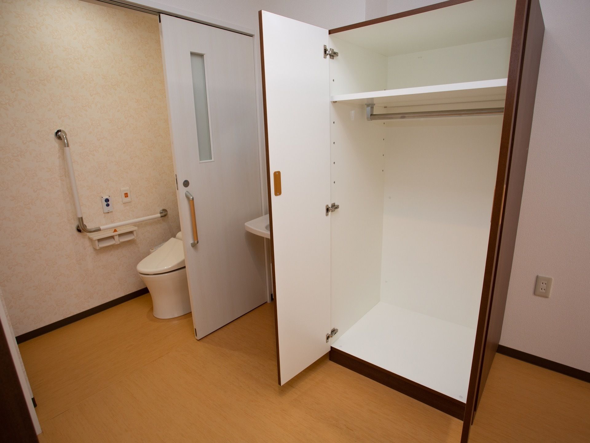 トイレ内は広めになっていて、手すり、緊急ボタンが設置されている。トイレの扉がスライドドアになっている。