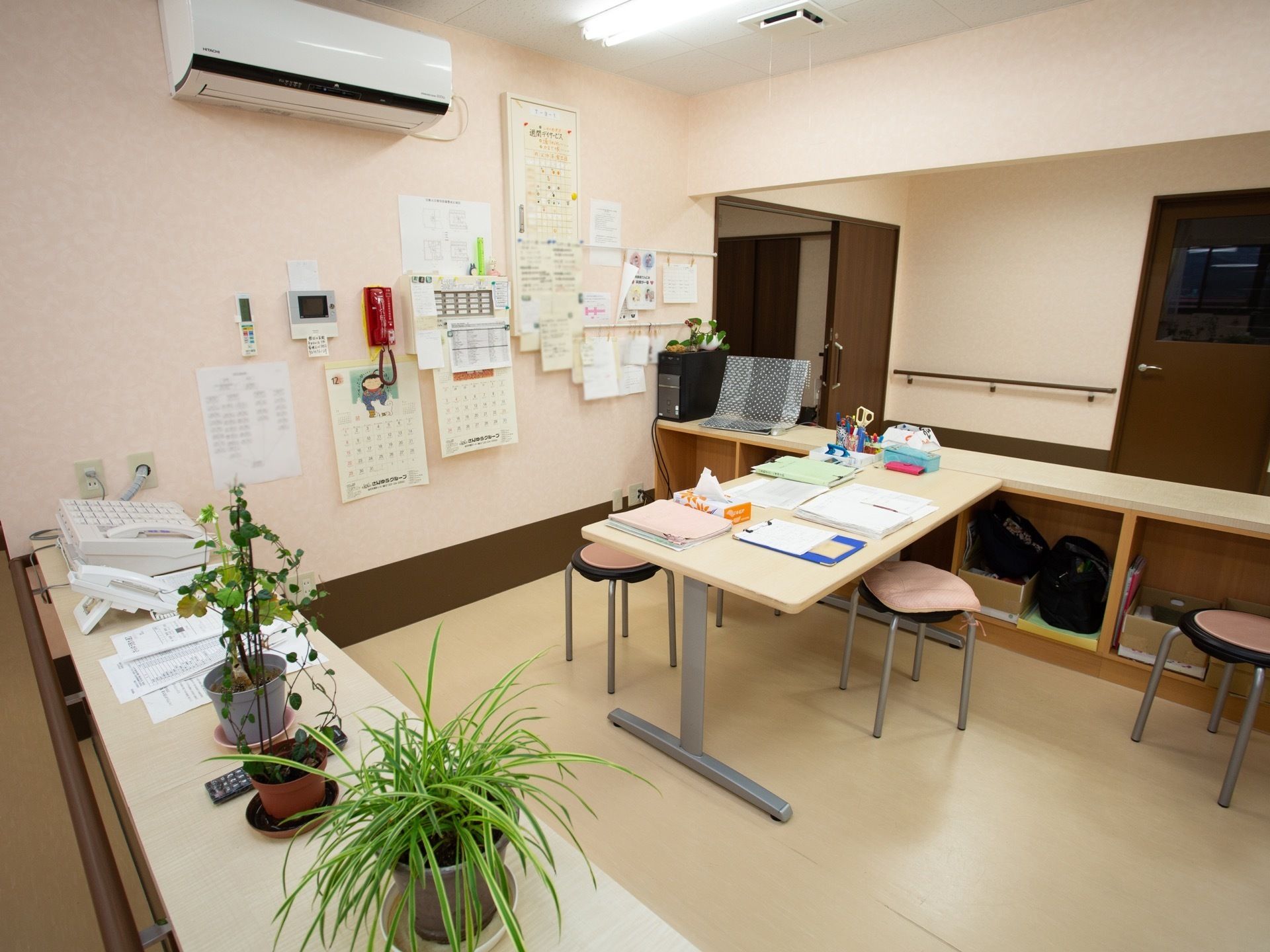 スタッフルームが設けられている。カウンターは受付になっており、観葉植物や電話が設置されている。エアコンが備わっている。