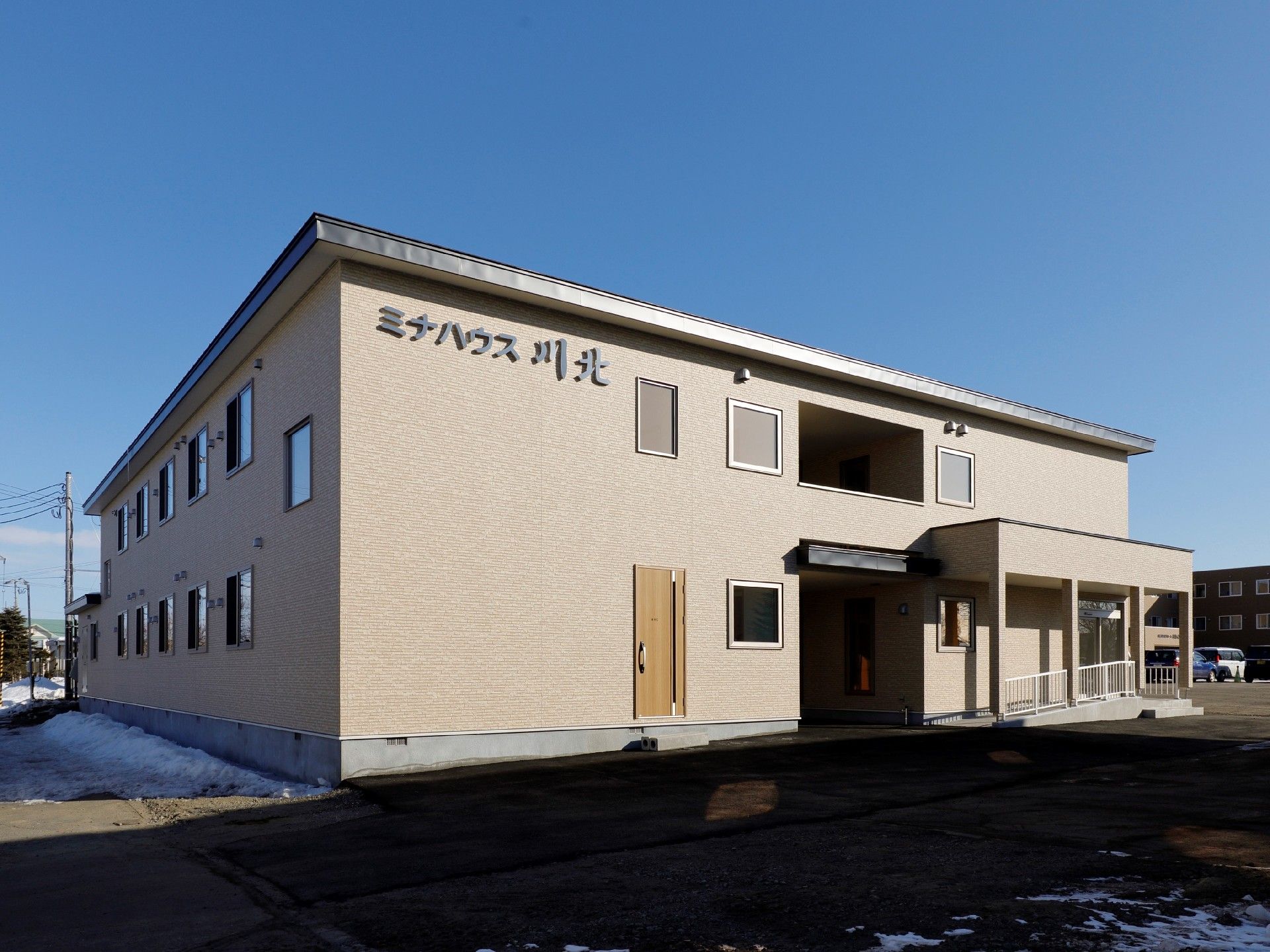 安定感のあるブラウン調の２階建ての建物。２階部分にはホームの名前が書かれている。