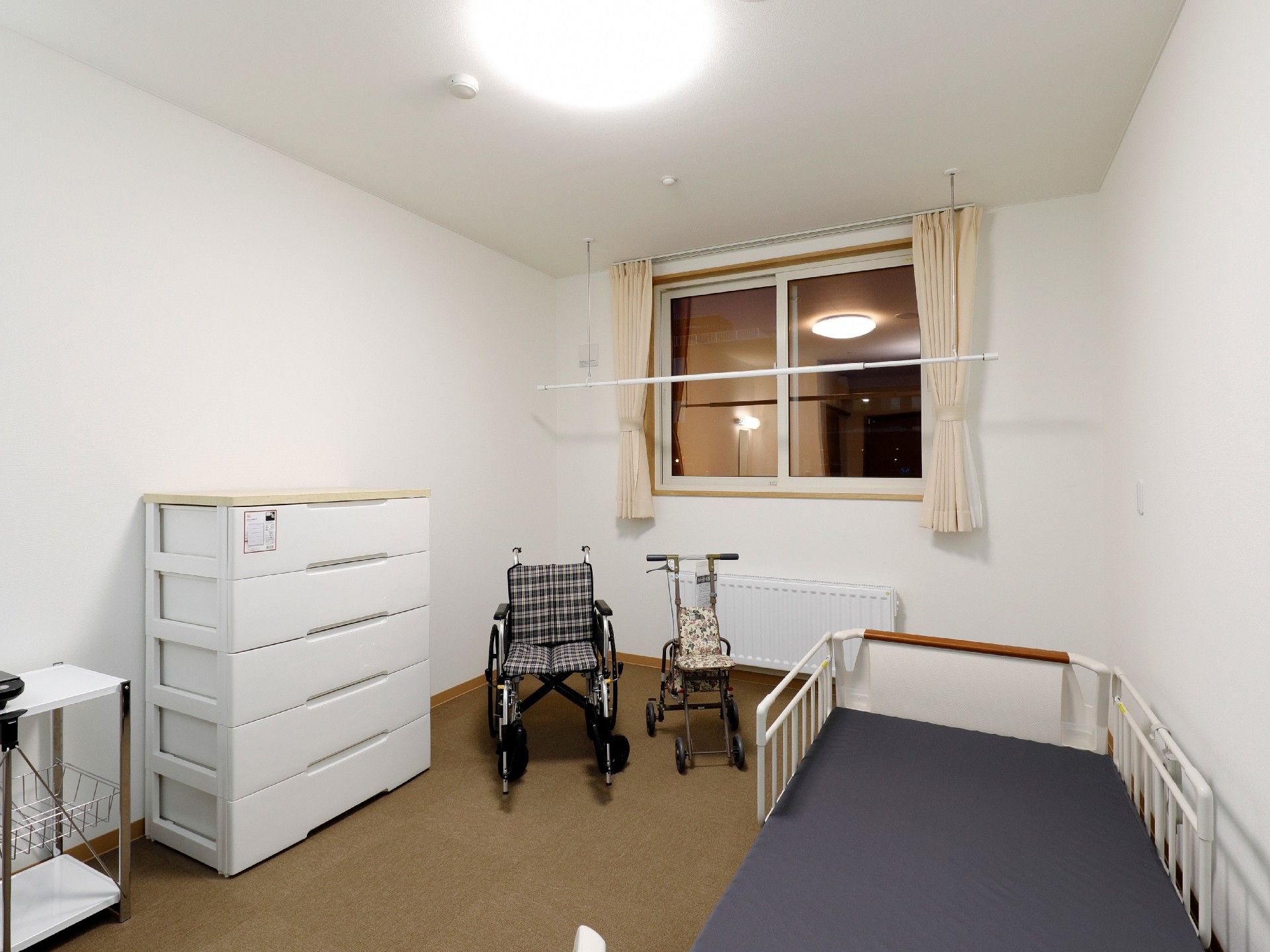 一人部屋の居室ドア付近から内部を見渡した様子。家具などは置かれていないシンプルな内装。