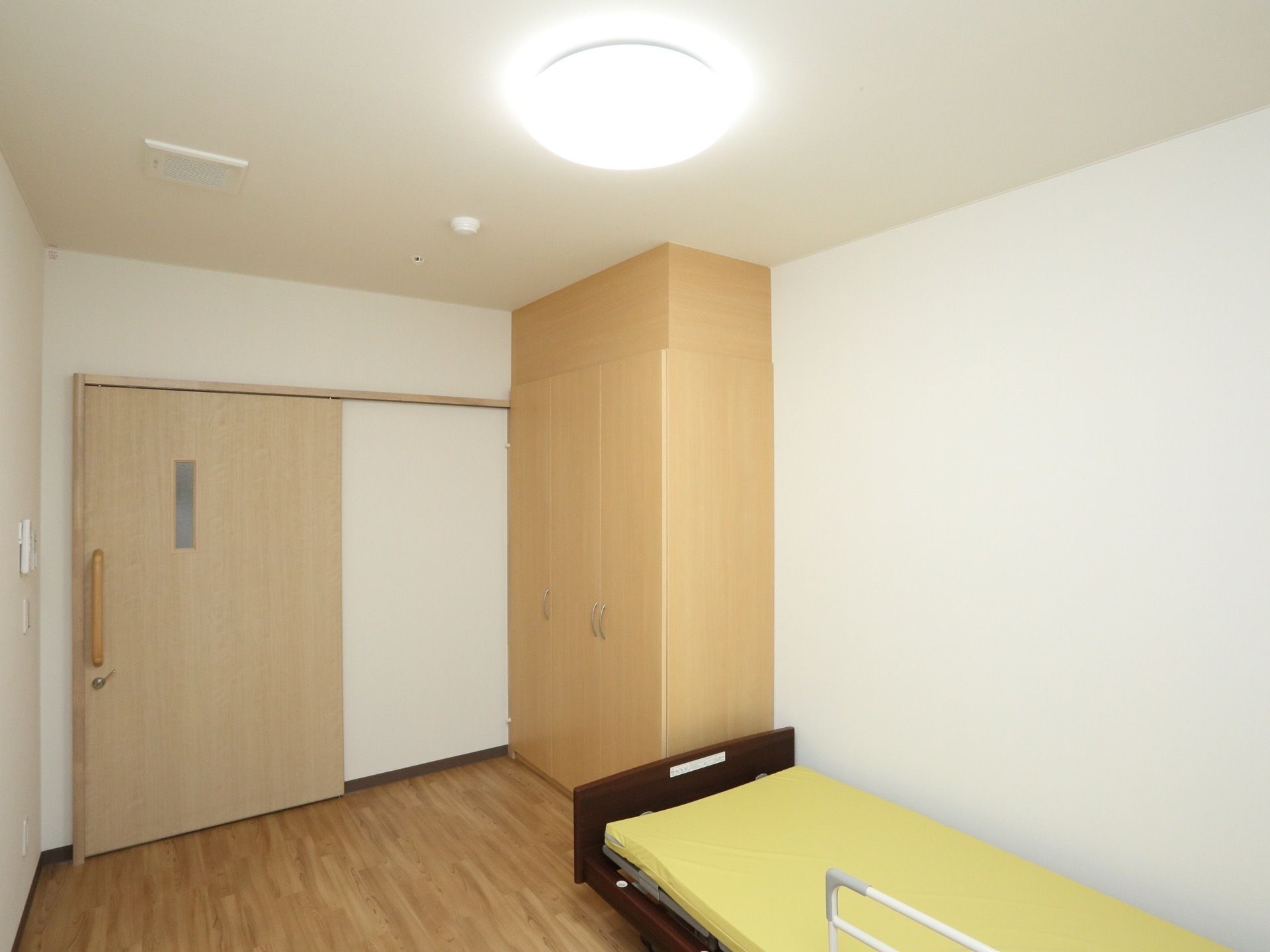 収納力のある木製のクローゼットが完備された居室である。扉は引き戸式仕様で、明かり窓が備えつけられている。