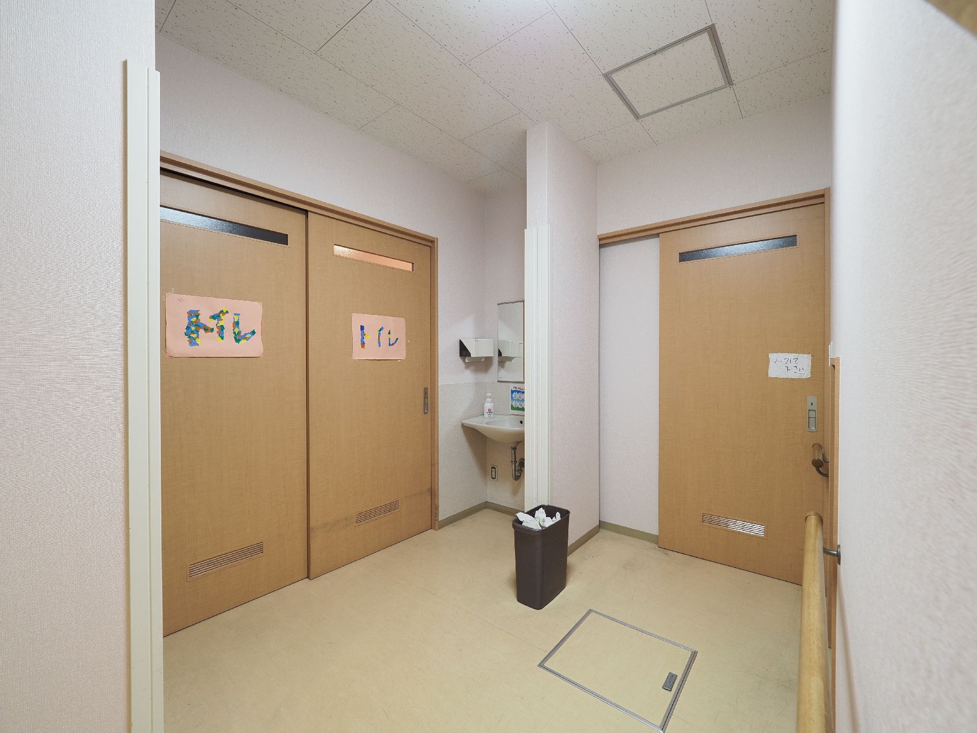 トイレの扉は幅を広くとってある引き戸である。扉の脇には洗面台が設置されている。扉の前はゆったりとしたスペースを設けている。