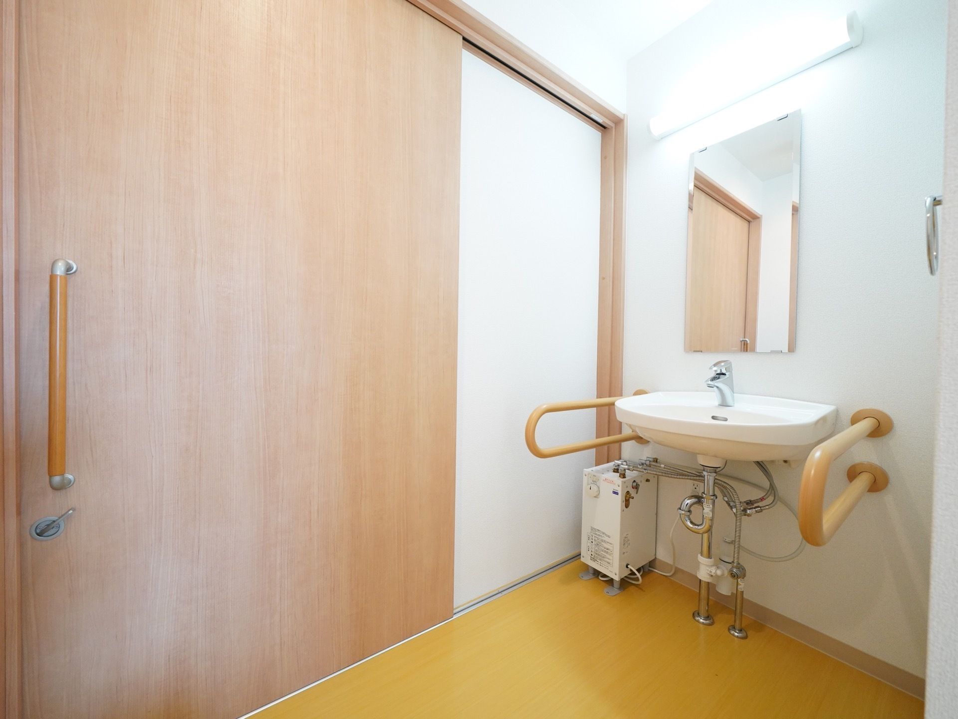 トイレ個室内に洗面台が併設されている。大の左右には安全バーが設置されているので安心してご利用いただける。