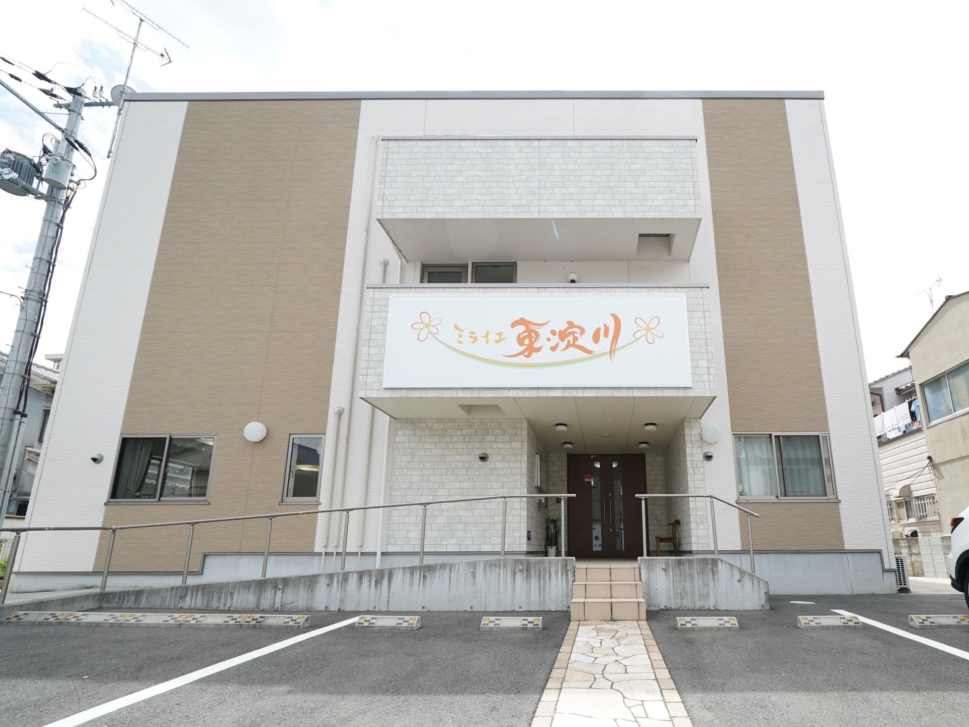 エントランスへの通路はスロープと階段の両方が用意されていて、誰でも利用しやすいよう配慮されている。駐車場も目の前なので移動の負担もない。