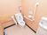 明るいピンクの壁紙の清潔感あふれるトイレである。壁には手すりがあり、便座の前には洗面台が設置されている。