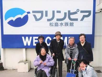外出時に水族館に行ったときの写真。高齢者とスタッフ