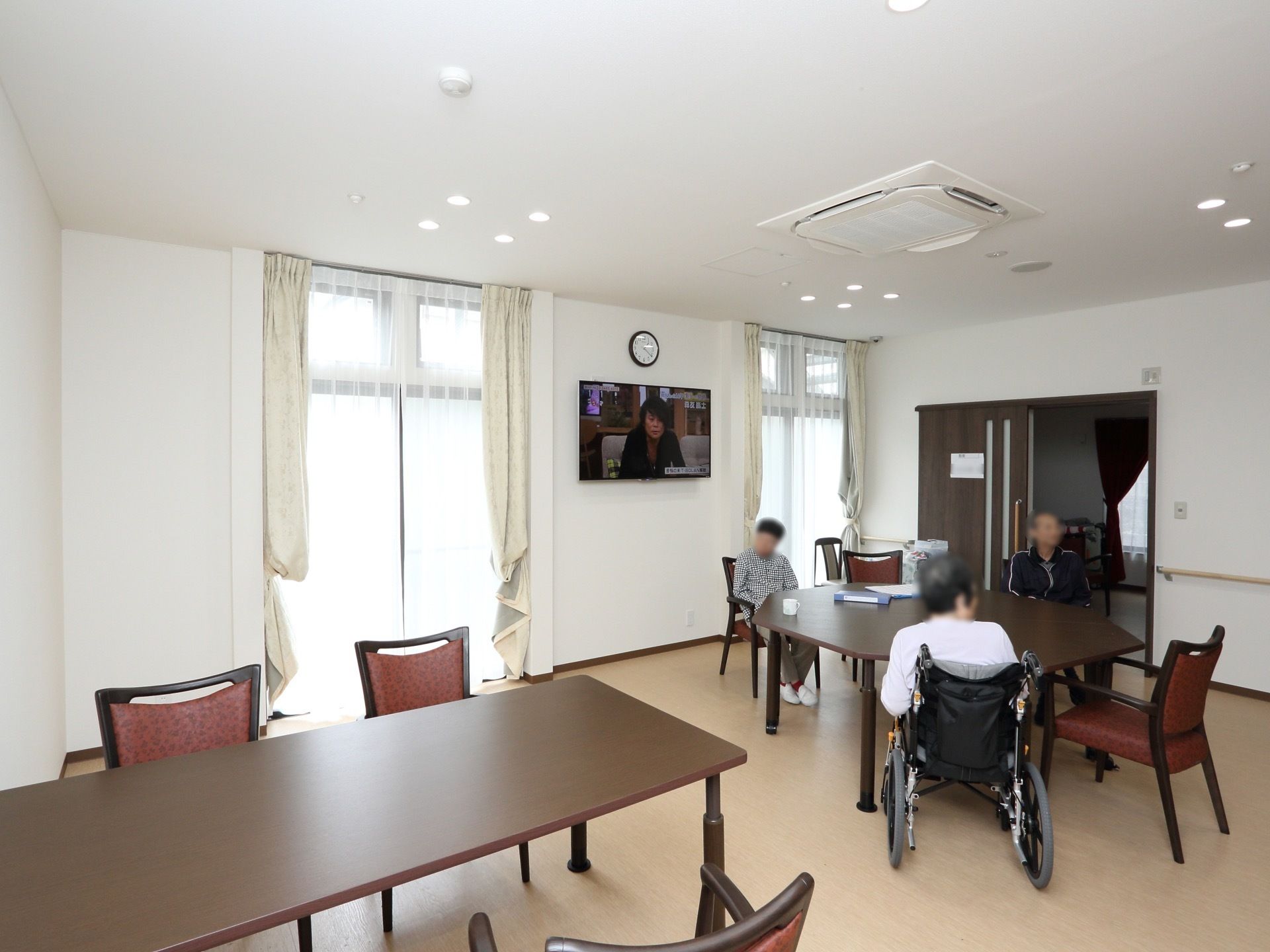 天井に複数の小さな丸い照明が設置されている。車椅子をご利用の方もゆったり過ごせるスペースが確保されている。