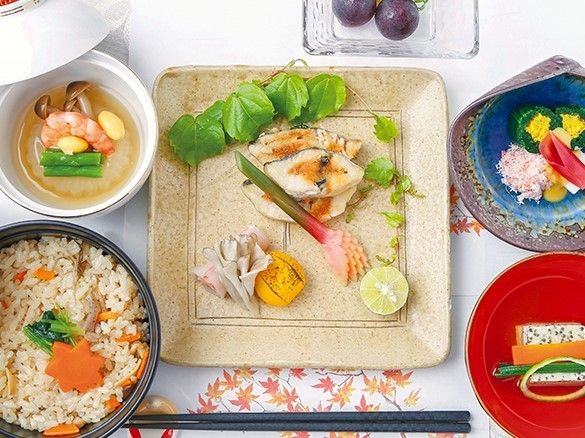 趣のある器に盛られた料理の数々。炊き込みご飯や魚、蕪のあんかけ、ブドウなど。