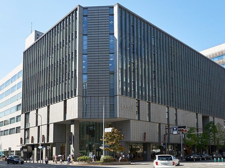 大きなショッピングビル。都会的なスタイリッシュなデザイン。周辺にはタクシーや車が行きかっている。