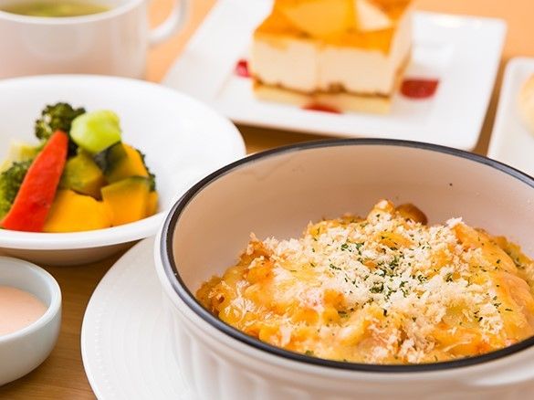 粉チーズのかかったグラタンのようなメインと温野菜、デザートの洋食メニュー。
