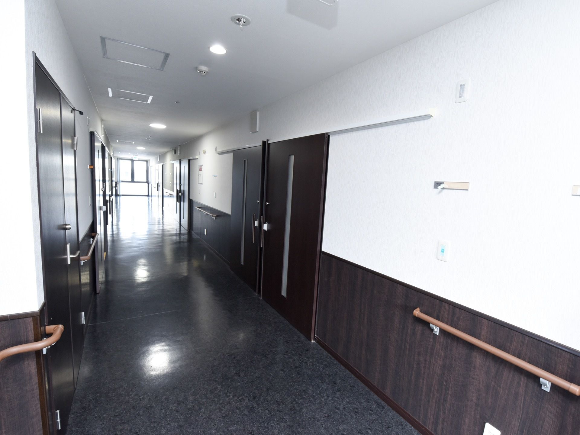 居室の扉は黒色になっており、モダンな雰囲気の廊下である。スライド式で、安全に開け閉めすることができる。