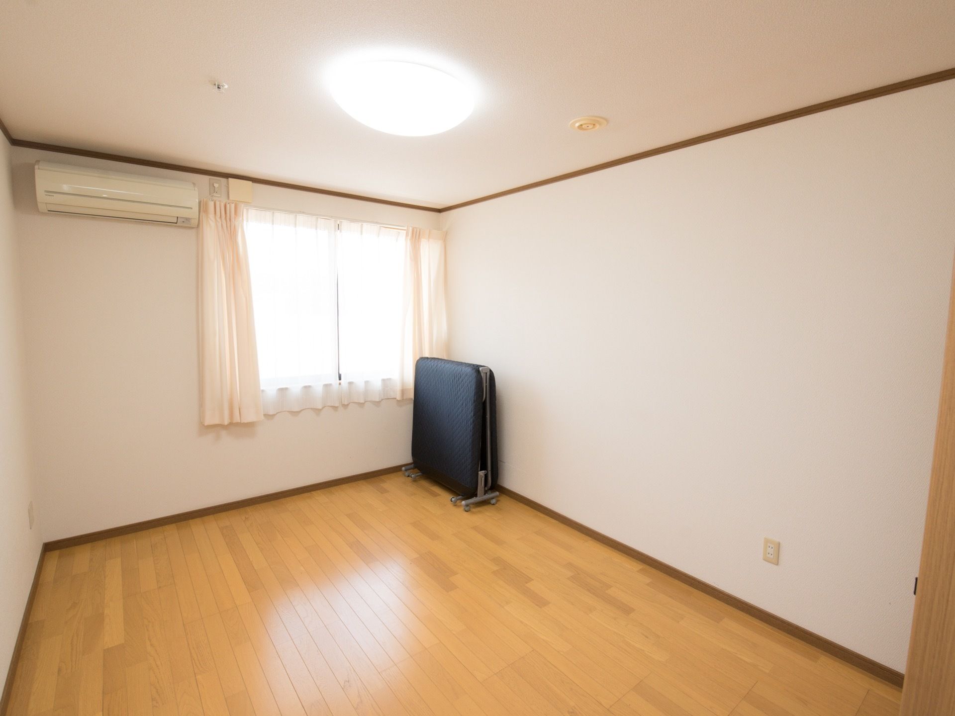 窓から陽射しが差し込む明るい居室である。エアコンが取りつけられており、１年中快適に過ごすことができる。