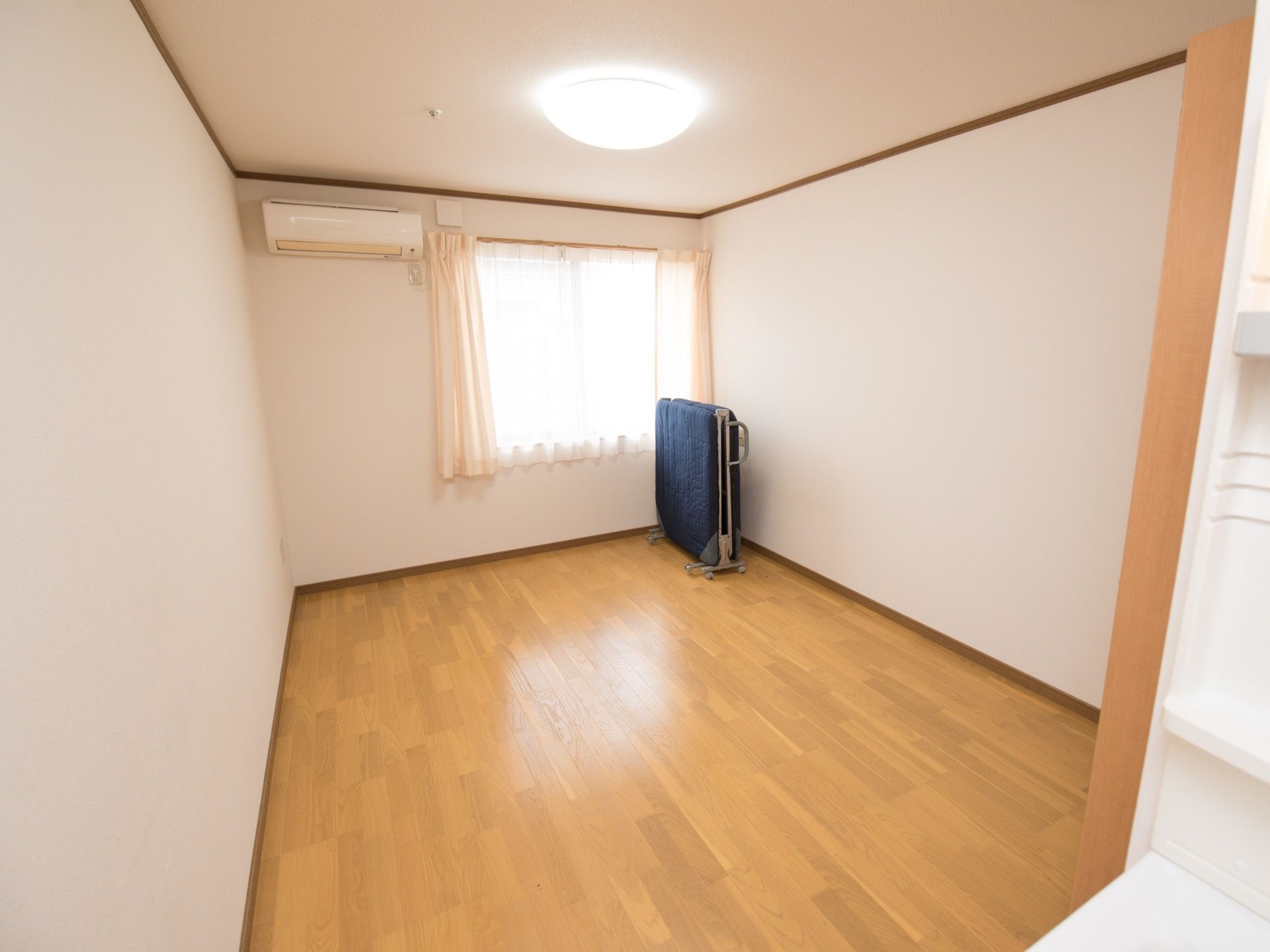 居室内にはベッドが備えつけで置いてある。折り畳んで移動できるタイプになっており、好きな場所に配置できる。