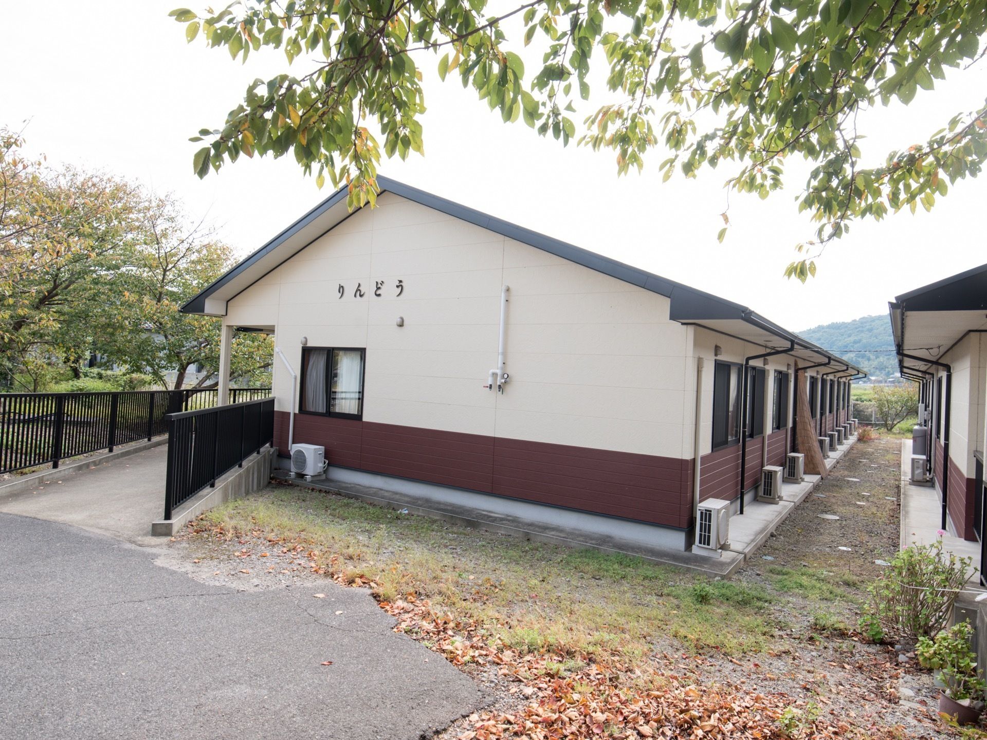 全ての居室の外側に室外機が置いてあり、エアコン完備であることが外からわかる。建物本体の周囲は砂利を敷いたものとなっている。