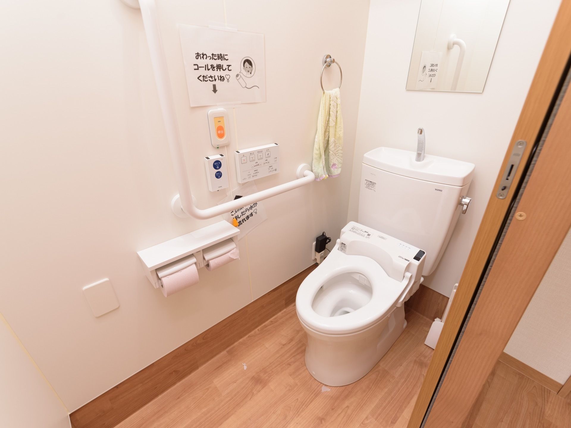 引き戸で仕切られたスペースに蓋のない洋式便器が据えてある。壁面には各種操作ボタンが設置されており、必要な動作についての説明が掲示されている。