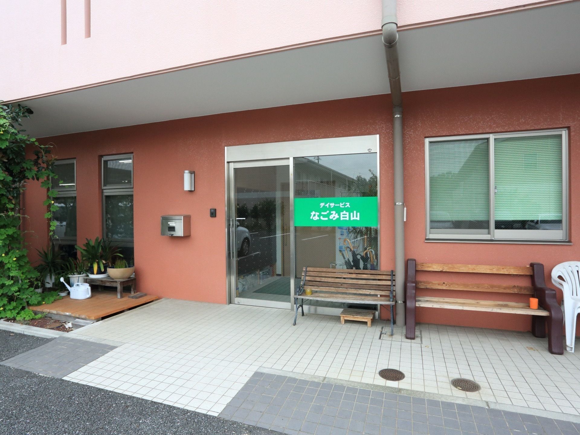 医療従事者と車いすに乗る高齢者、公園で散策している様子