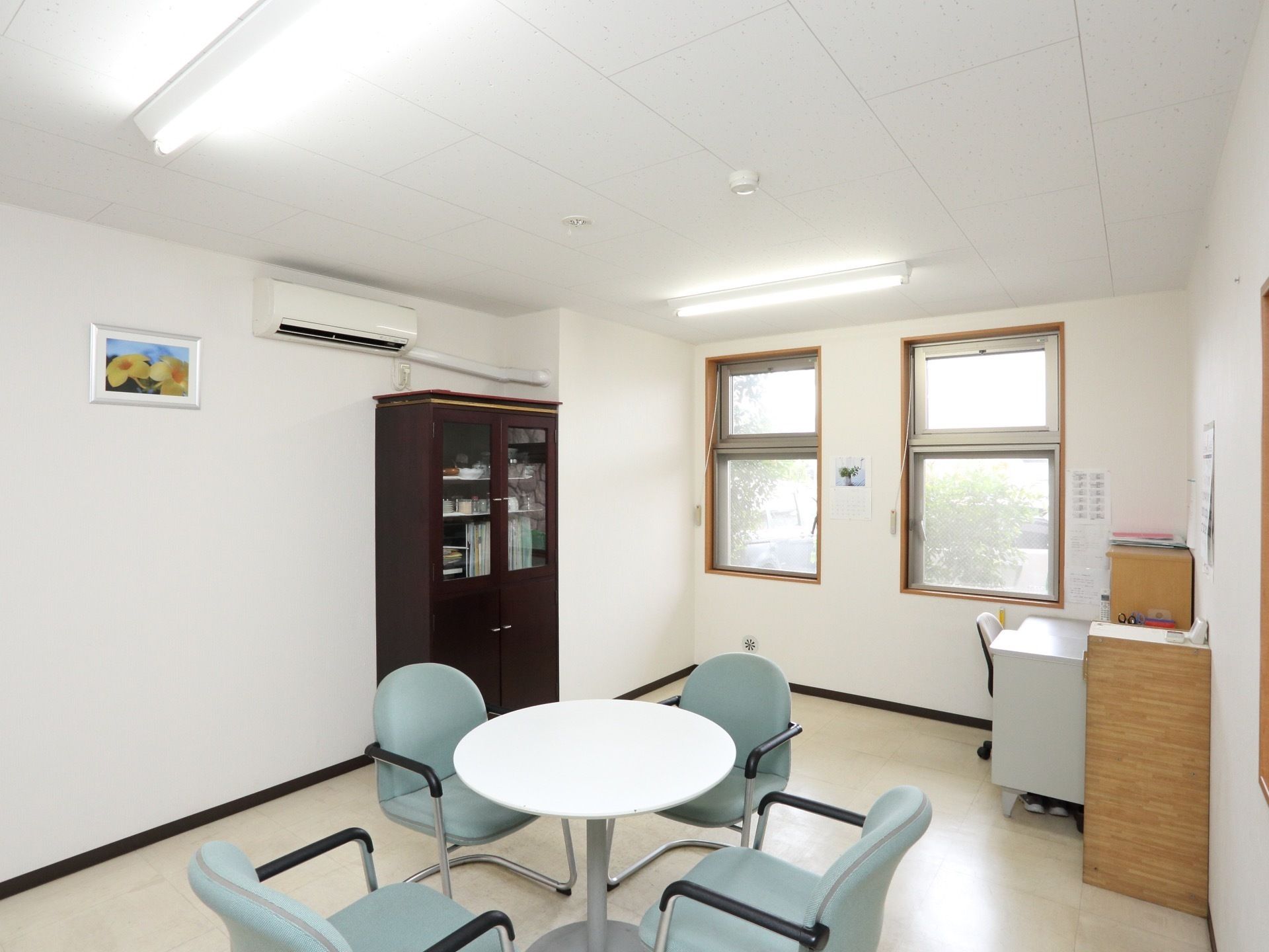 ひとりで部屋でくつろいでいる男性。ホワイトを基調とした部屋で明るい様子が分かる