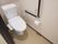 白を基調とした清潔感のある個室タイプの洋式トイレである。壁には紐がついたナースコールが取りつけられている。