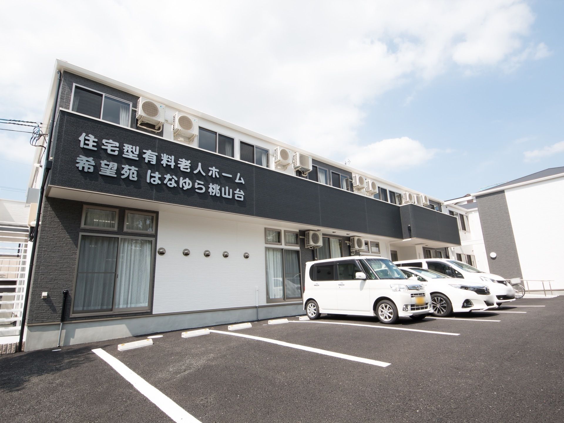 2階建てのホームの外観は白と黒でまとめられていて、ホームの玄関にはスロープが付けられている。