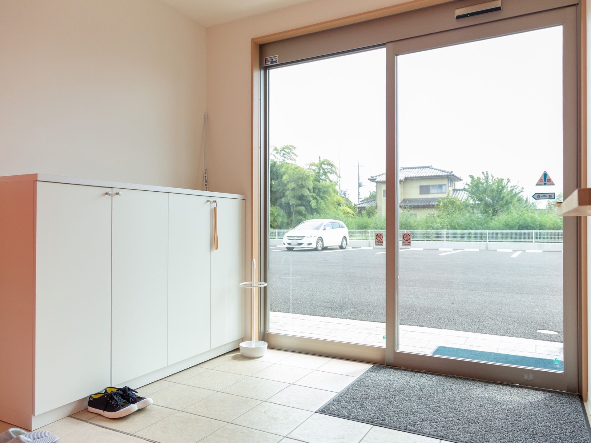 車いすに乗る高齢者とそれを押す人。こちらを見て頬電でいる様子