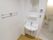 脱衣所兼トイレには、洗面台を設置している。壁には、タオルハンガーと鏡、給湯スイッチと物乗せ題がついている。