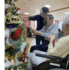 笑顔のヘルパーに囲まれた車椅子に座っている高齢女性
